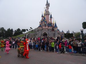 A cuddly tiger character strolls past a castle