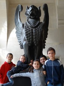 Five children stand by a statue in a French chateau