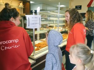 Two children help Eurocamp couriers buy croissants and baguettes in the parc shop for the special kids club breakfast at Berny Riviere in northern France