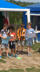 Four boys pretend they're TV presenters as they take part in a show at Eurocamp's kids clubs at Berny Riviere parc